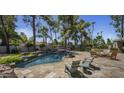 Landscaped backyard features a pool with rock accents, waterfall and ample seating at 10685 E Cinnabar Ave, Scottsdale, AZ 85258