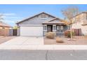 Single-story house with gray exterior, attached garage, and neatly landscaped front yard at 11004 N 154Th Ln, Surprise, AZ 85379