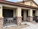 Covered porch with stone pillars and wrought-iron fence at 14960 W Cottonwood St, Surprise, AZ 85374