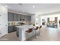 Modern kitchen with gray cabinets, white island, and stainless steel appliances at 16917 W Jenan Dr, Surprise, AZ 85388