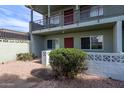 Two-story condo with rock landscaping and a large bush, showing the entryway at 1702 W Tuckey Ln # 123, Phoenix, AZ 85015