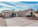 Beautiful single-story home boasts three-car garage, complemented by mature landscaping and a spacious driveway at 17347 W Statler St, Surprise, AZ 85388