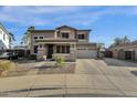 Two story house exterior with stone accents, large windows and double car garage at 18651 E Superstition Dr, Queen Creek, AZ 85142