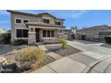 Two story house exterior with stone accents, large windows and double car garage at 18651 E Superstition Dr, Queen Creek, AZ 85142