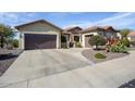 Two-car garage with a large driveway and desert landscaping at 20642 N 268Th Dr, Buckeye, AZ 85396