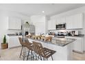 Bright kitchen featuring white cabinetry, stainless steel appliances, granite countertops, and an island with seating at 28242 N Nealite Dr, San Tan Valley, AZ 85143