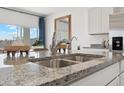 Close-up of kitchen sink and granite countertop, stainless steel appliances, and view to the outdoors at 28242 N Nealite Dr, San Tan Valley, AZ 85143