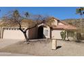 Tan stucco house with tile roof, arched entryway, and two-car garage at 3626 E Thunderhill Pl, Phoenix, AZ 85044