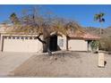 Tan stucco house with tile roof, arched entryway, and mature tree in front at 3626 E Thunderhill Pl, Phoenix, AZ 85044