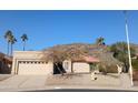 Tan stucco house with tile roof, two-car garage, and desert landscaping at 3626 E Thunderhill Pl, Phoenix, AZ 85044