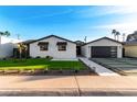 Charming renovated house boasting a stone facade, low-maintenance landscaping, and a modern garage at 6331 E Earll Dr, Scottsdale, AZ 85251