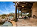 Backyard area with stone flooring, lounge chairs, spa and lush desert landscape at 10712 E Prospect Point Dr, Scottsdale, AZ 85262