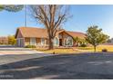 Spacious single-story home with an attached garage, tile roof, and a tree-shaded front yard at 2702 E Vaughn Ave, Gilbert, AZ 85234