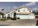 Charming two-story home with a three-car garage, desert landscaping, and an American flag at 3554 E Camino Cir, Mesa, AZ 85213