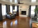 Spacious living room featuring hardwood floors and a fireplace at 3554 E Camino Cir, Mesa, AZ 85213