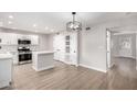 Modern kitchen with island, white cabinets and hardwood floors at 4432 E Belleview St, Phoenix, AZ 85008