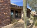 Front entrance featuring desert landscaping with a stone accent wall and modern door and windows at 10040 E Happy Valley Rd # 300, Scottsdale, AZ 85255