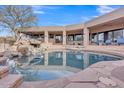 Resort-style pool area with rock waterfall feature and ample lounge space with desert views at 10040 E Happy Valley Rd # 300, Scottsdale, AZ 85255