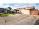 Ranch style home with a long driveway and grassy yard at 1028 E Emerald Ave, Mesa, AZ 85204