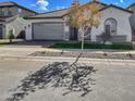 One-story house with gray garage and a tree in front at 15787 W Mariposa Grande --, Surprise, AZ 85387