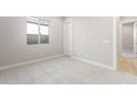 Neutral bedroom with carpet, a window, baseboards, and door leading to the hall at 18180 E Tiffany Dr, Queen Creek, AZ 85142