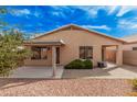 Backyard featuring red rock landscaping, covered patio, privacy shrubs and a walkway at 19850 N 110Th Ln, Peoria, AZ 85373
