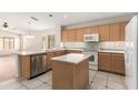 Bright kitchen features light wood cabinets, stainless steel appliances, and a central island at 19850 N 110Th Ln, Peoria, AZ 85373