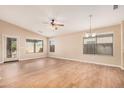 Spacious living room features laminated wood floors, large windows and modern ceiling fan at 19850 N 110Th Ln, Peoria, AZ 85373