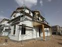 New two-story home under construction featuring scaffolding, covered porch with wood supports, and visible building wrap at 26021 N 23Rd Ave, Phoenix, AZ 85085