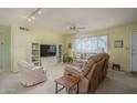 Cozy living room featuring plush seating, neutral carpet, and bright, natural light at 4215 W Griswold Rd, Phoenix, AZ 85051