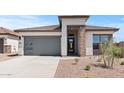 Attractive single-story home showcasing a modern garage door, stone accents and desert landscaping at 564 E Aurora Dr, San Tan Valley, AZ 85140