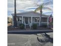 Inviting single-story home featuring a cozy front porch, a palm tree, and an attached covered carport at 11411 N 91St Ave # 225, Peoria, AZ 85345