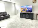 Living room with dark leather couch, large TV, and marble-look flooring at 1180 E Marlin Dr, Chandler, AZ 85286