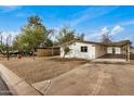 Single story home with carport, gravel yard, and wooden fence at 136 S 90Th Pl, Mesa, AZ 85208