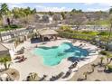 Aerial view of the community pool with ample seating, cabana and lush landscaping with palm trees, great for relaxation and recreation at 1578 S Sabino Ct, Gilbert, AZ 85296