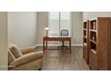 Cozy home office featuring a wooden desk, bookshelves, and comfortable armchair at 16954 W Palm Ln, Goodyear, AZ 85395
