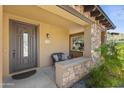 Inviting front porch with stone accents, seating, and covered entry way at 17763 N 93Rd Way, Scottsdale, AZ 85255