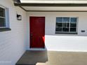 Close up view of a red front door, white brick exterior and new outdoor lighting at 2724 W Pierson St, Phoenix, AZ 85017