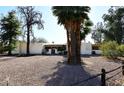 Spacious home with a stone driveway, mature trees, and a gated front entrance, offering privacy and curb appeal at 7043 E Ann Way, Scottsdale, AZ 85254