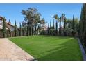 Landscaped backyard with stone patio and grassy area at 1207 W Sea Bass Ct, Gilbert, AZ 85233