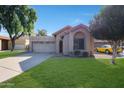 Cute single-story home with a two-car garage and well-manicured lawn at 1207 W Sea Bass Ct, Gilbert, AZ 85233