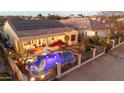 Stunning nighttime view of a home with a pool and spa, solar panels, and attractive landscaping at 14335 W Monte Vista Rd, Goodyear, AZ 85395