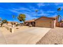 Tan house with a two-car garage and gravel driveway at 14409 N 34Th Way, Phoenix, AZ 85032