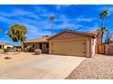 Tan house with a two-car garage and desert landscaping at 14409 N 34Th Way, Phoenix, AZ 85032