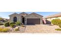 Single-story home featuring a brick driveway, desert landscaping, and a neutral exterior at 15804 N 109Th Dr, Sun City, AZ 85351