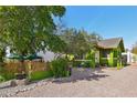 Exterior view of a green two-story home featuring a charming brick patio and mature trees at 1638 E Earll Dr, Phoenix, AZ 85016