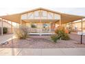 House exterior showcasing a covered porch and landscaping at 180 S Stardust Ln, Apache Junction, AZ 85120