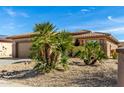 One-story house with palm trees and a two-car garage at 18727 N Desert Light Dr, Surprise, AZ 85387