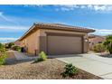 Tan house with a two-car garage and side yard at 18727 N Desert Light Dr, Surprise, AZ 85387