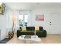 Bright living room with green sofa, wood floors, and fireplace at 1921 W Monte Vista Rd, Phoenix, AZ 85009